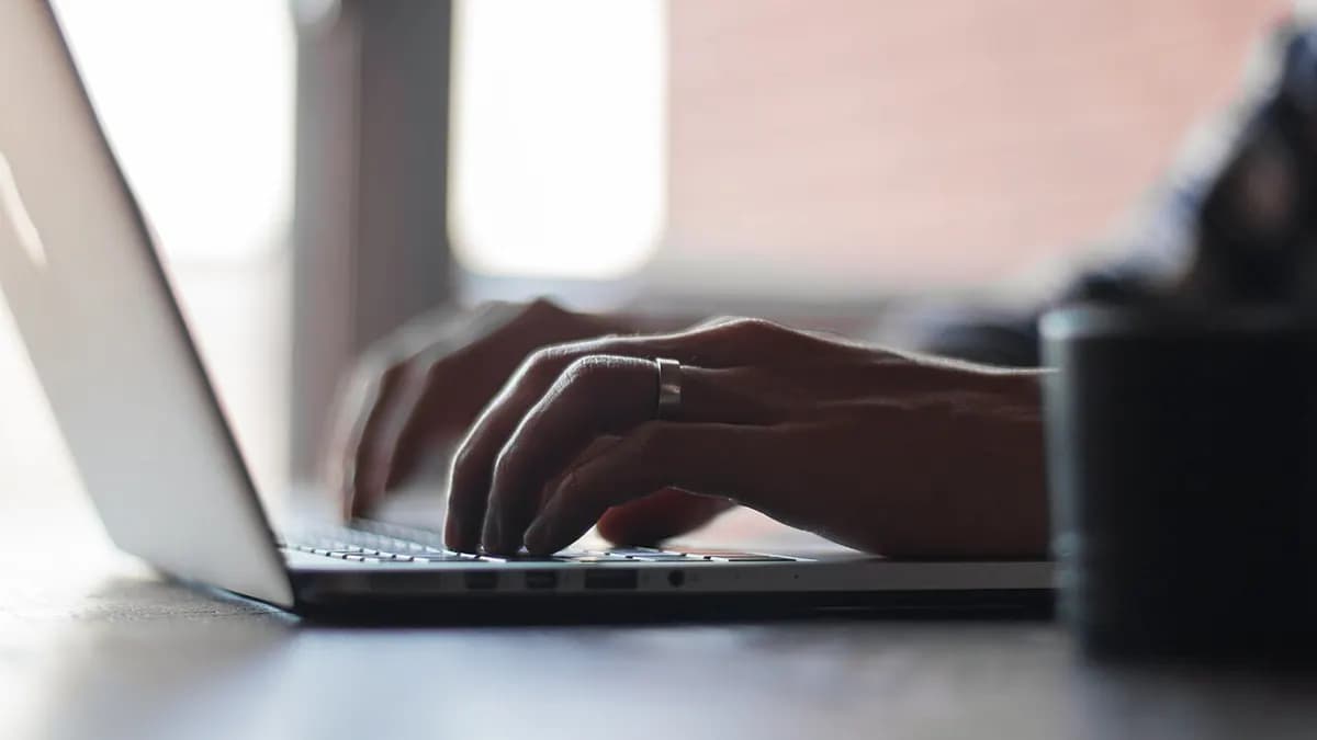 Hands typing on a laptop