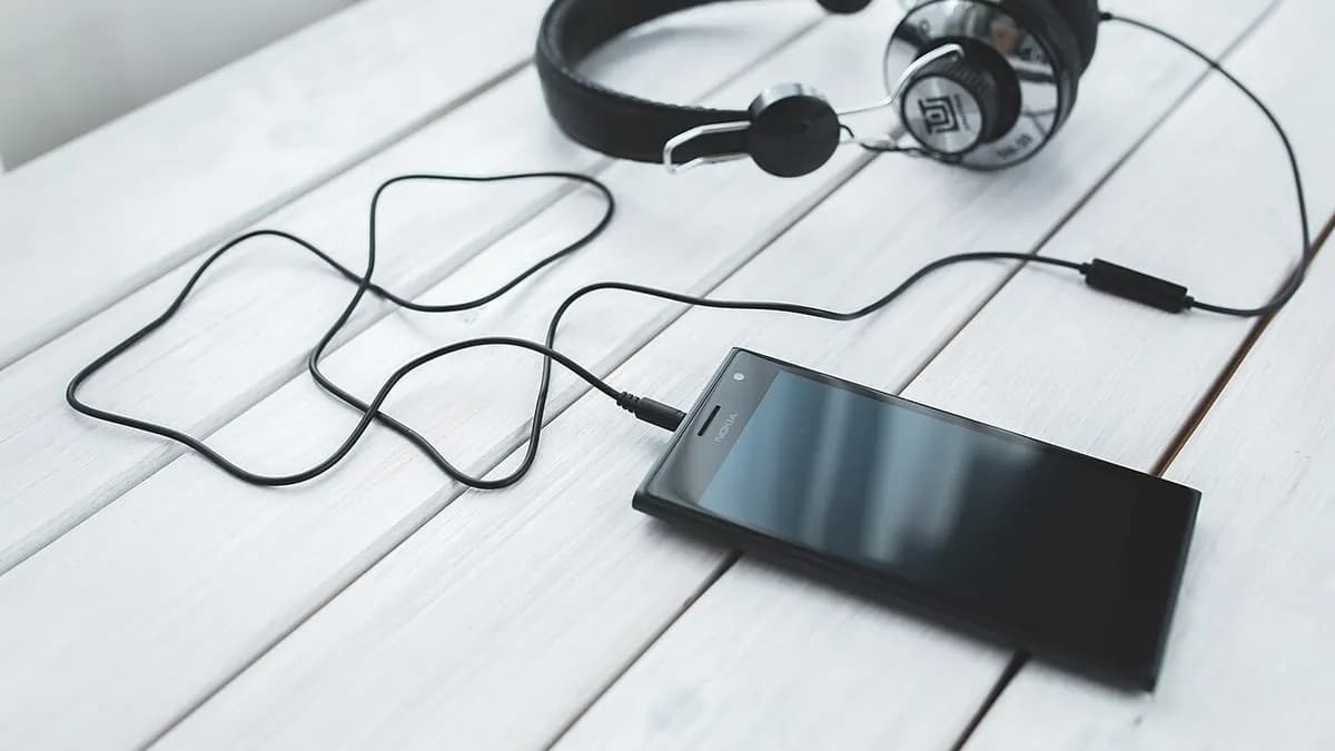 Headphones and a smartphone on a white table