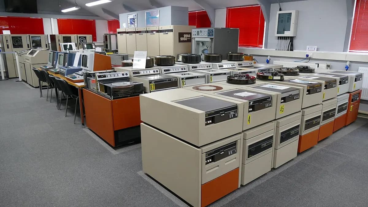 A hall of beige and orange mainframe cabinets and disk drive units from the 1980s