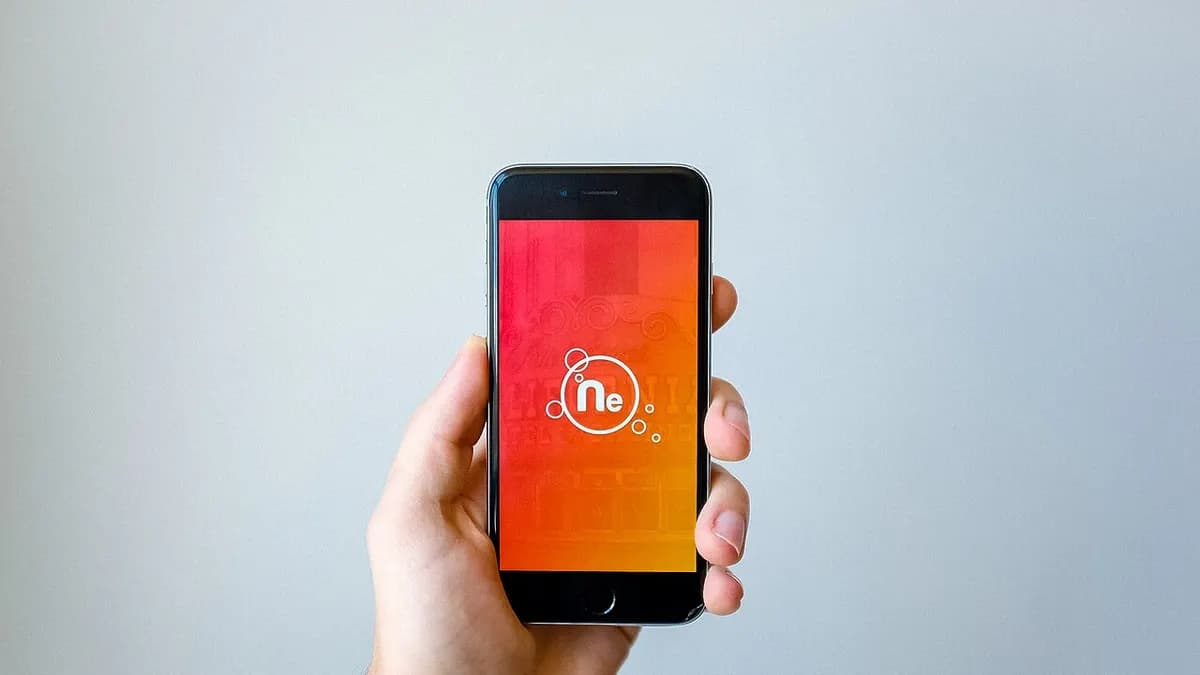 Hand holding a smartphone that shows an app opening screen