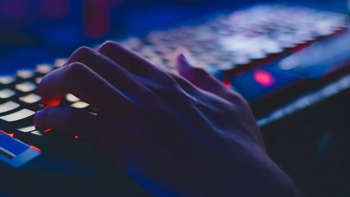 Hand on a backlit keyboard in blue light