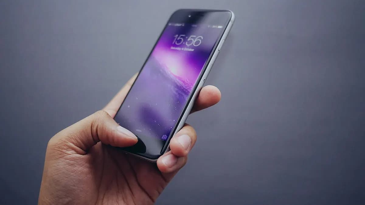 Hand holding a smartphone with its screen lit