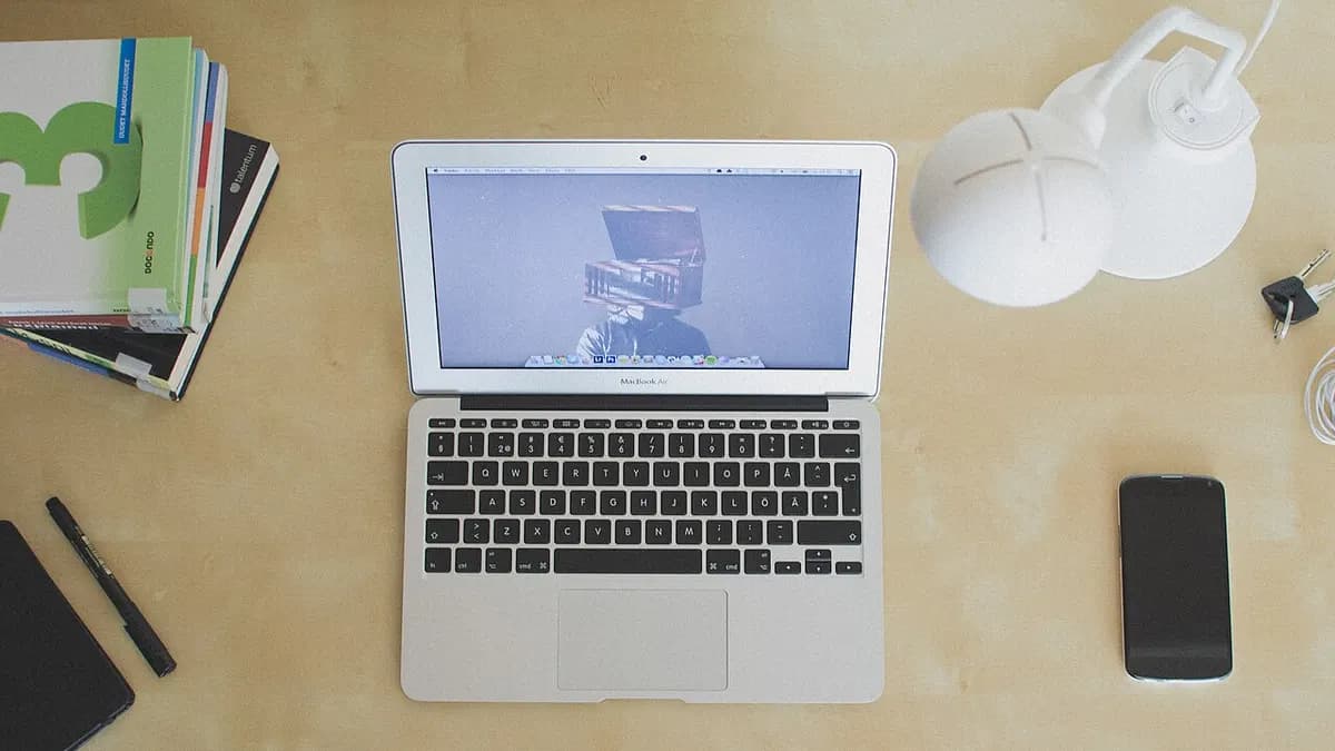 Laptop, notebook and phone on a desk seen from above