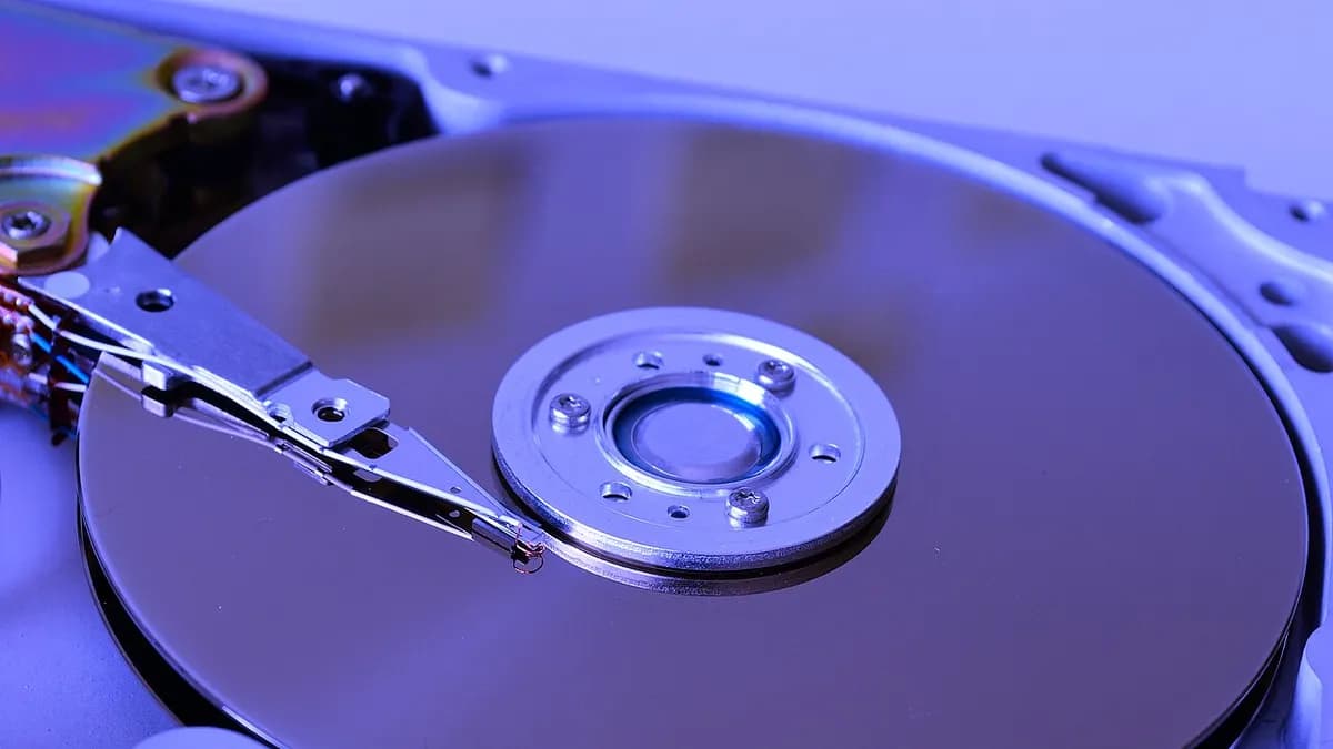 Close-up of an opened hard disk drive showing the platter and the read arm